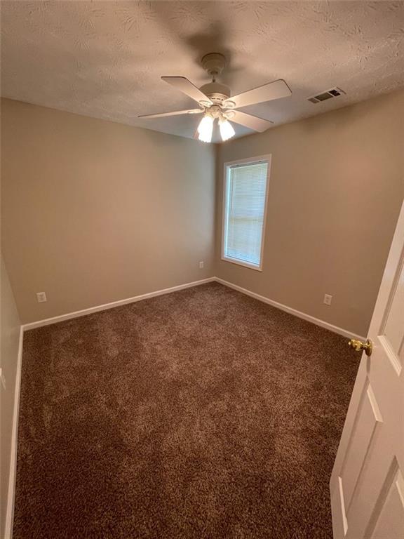 55 The Falls Boulevard Covington, GA 30016 - Photo 17 of 20 en empty room with window and chandelier fan