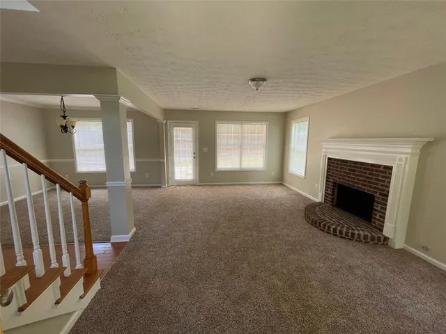 a view of a livingroom with a fireplace and window