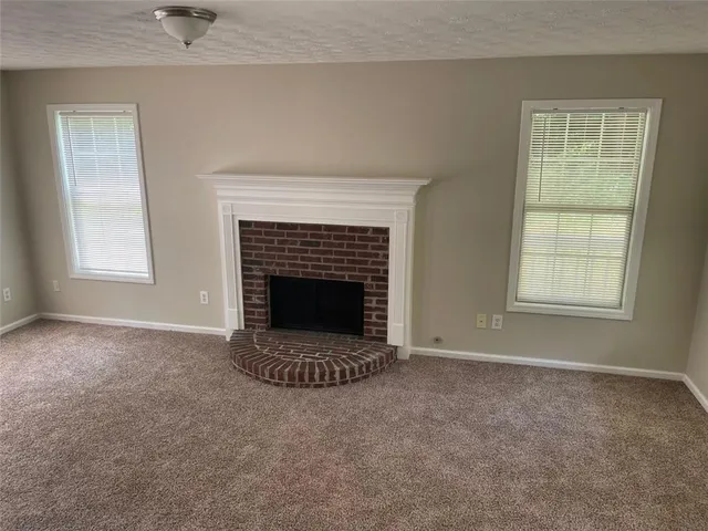 an empty room with a fireplace and window