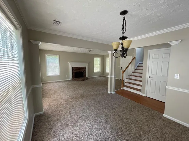 a view of empty room with fireplace and stairs
