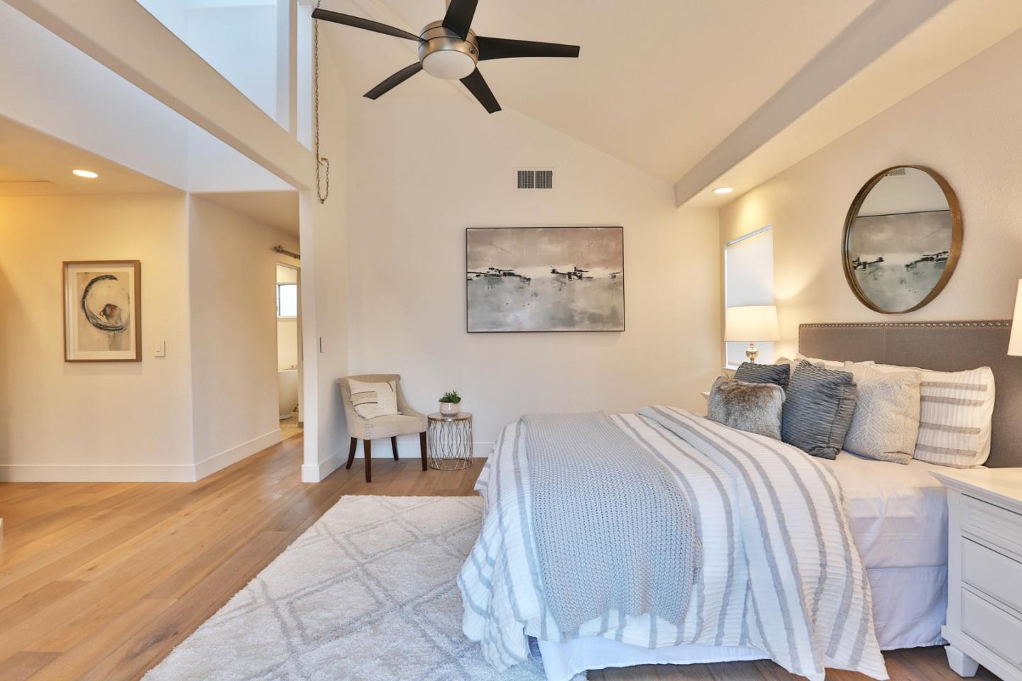22344 McClellan Road Cupertino, CA 95014 - Photo 17 of 42 a bedroom with a large bed and a chandelier