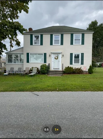 a front view of a house with a garden and plants