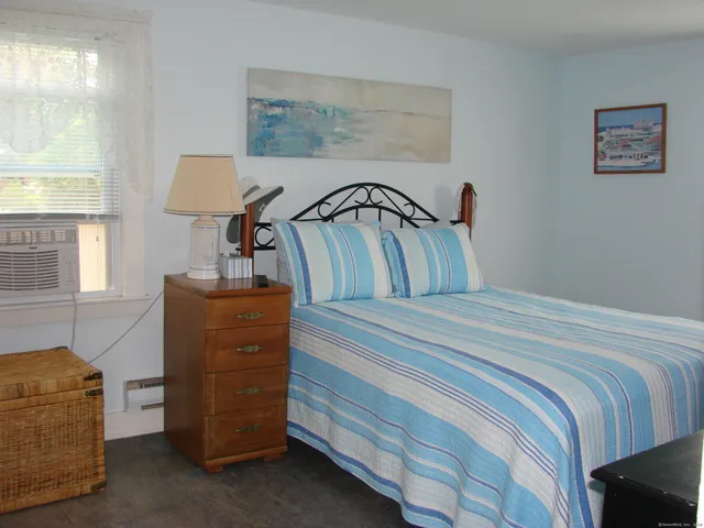 a bed room with a bed chair and a window