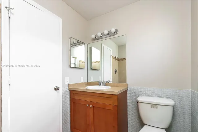 a bathroom with a toilet a sink and mirror