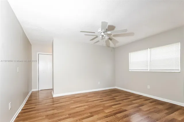 a view of a room with wooden floor and fan