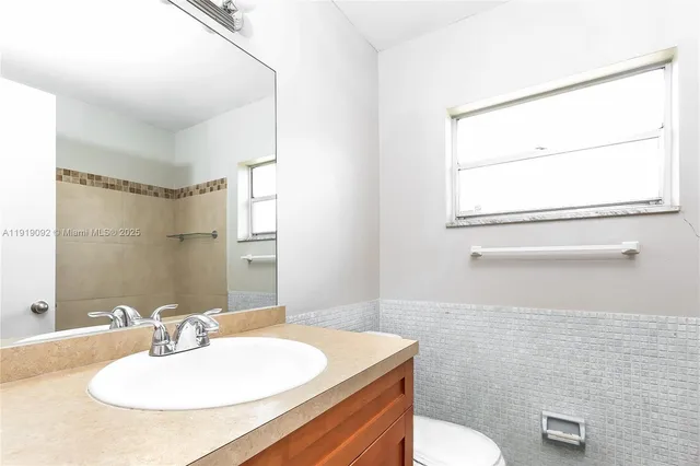 a bathroom with a sink toilet a mirror and vanity