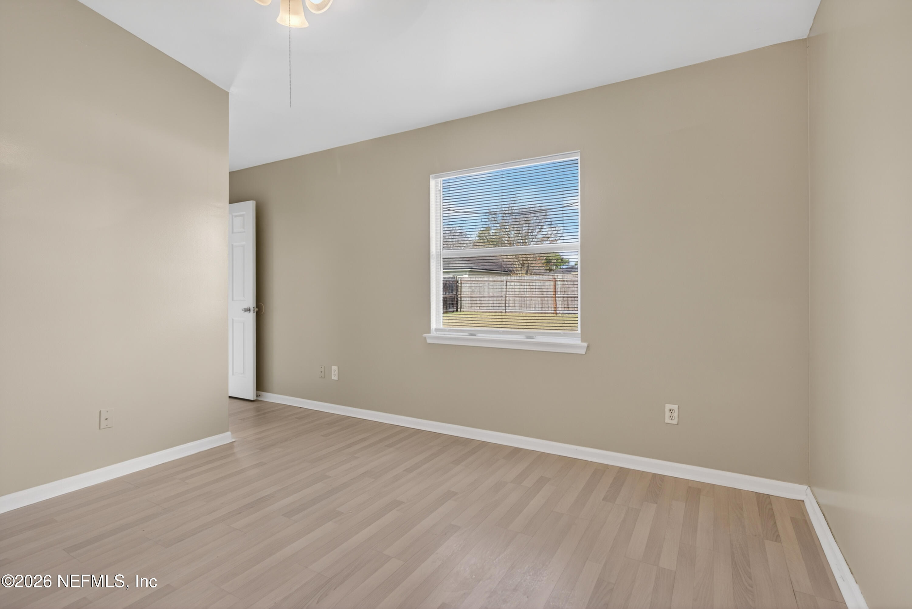 8745 Buzz Court Jacksonville, FL 32216 - Photo 13 of 23 an empty room with wooden floor and windows