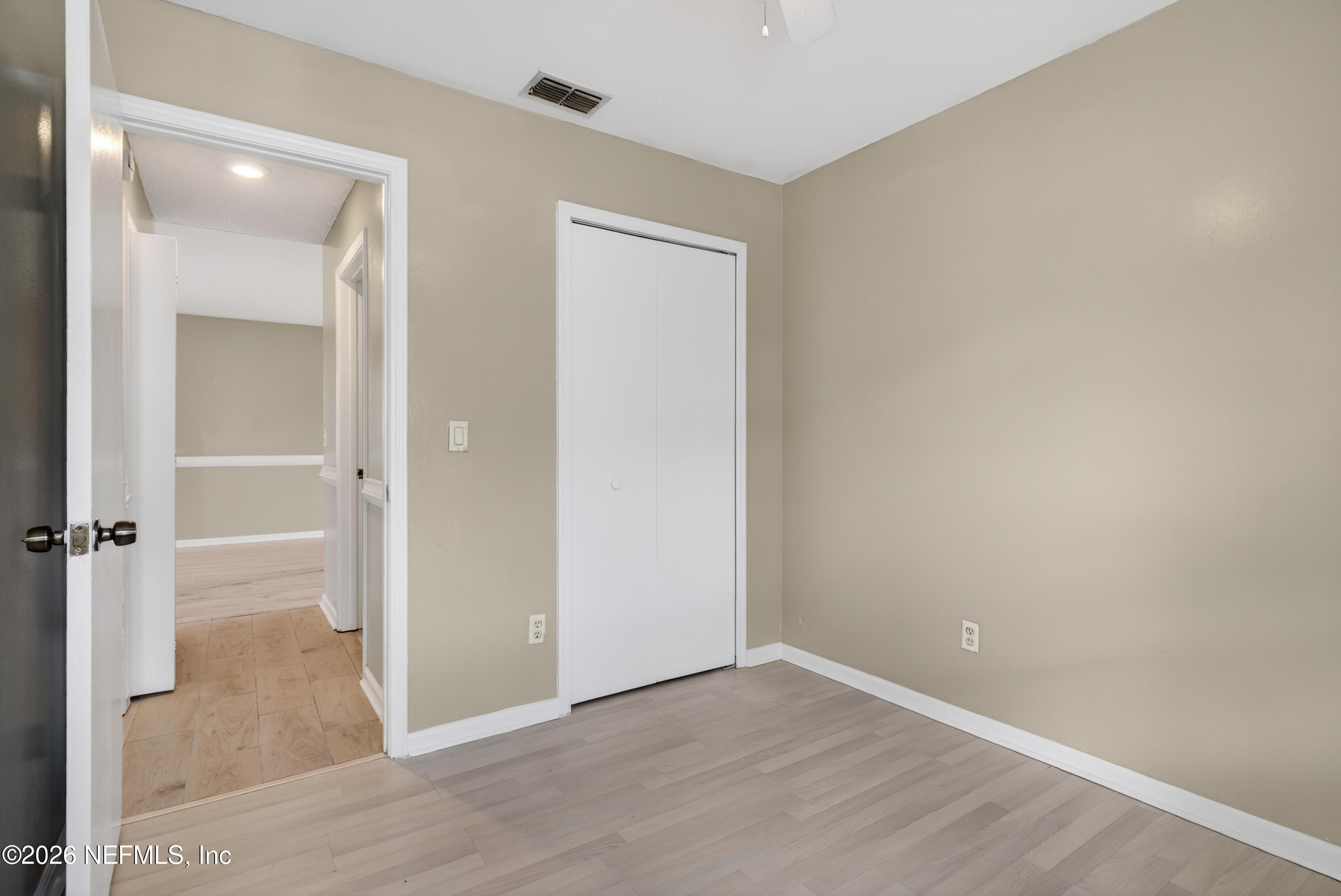 8745 Buzz Court Jacksonville, FL 32216 - Photo 19 of 23 an empty room with wooden floor and mirror