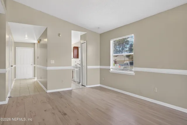 a view of a big room with wooden floor and windows