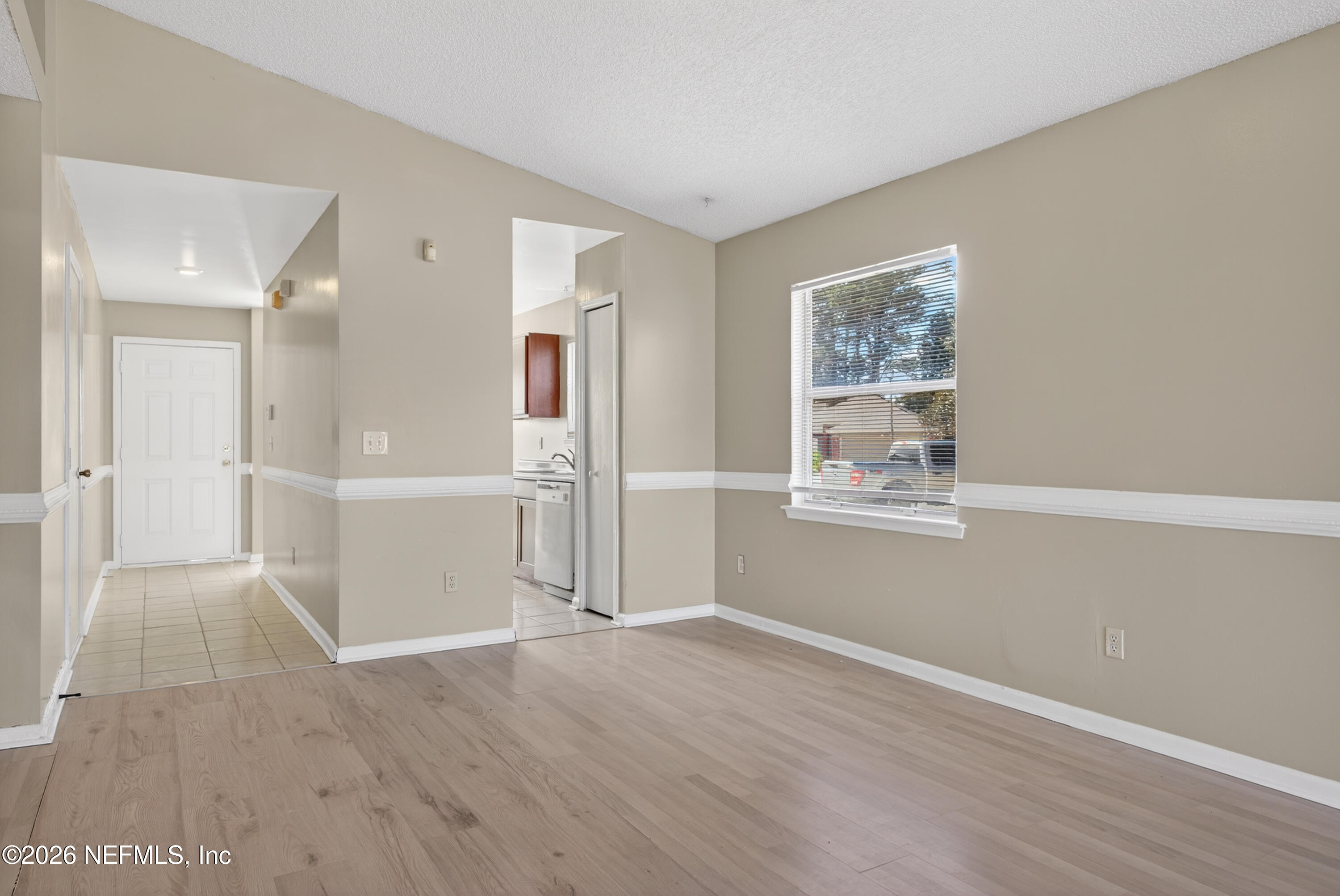 8745 Buzz Court Jacksonville, FL 32216 - Photo 7 of 23 a view of a big room with wooden floor and windows
