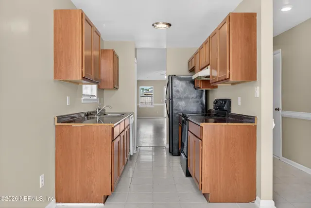 a kitchen with stainless steel appliances granite countertop a refrigerator a sink and a stove