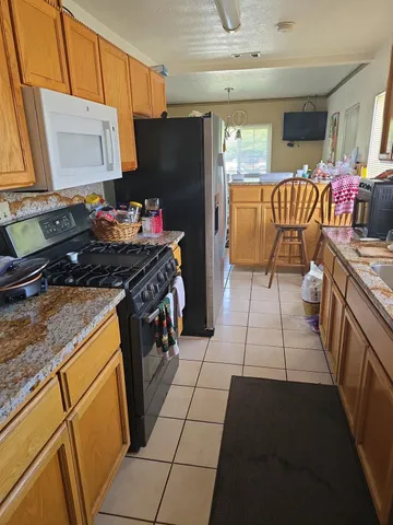 a kitchen with a stove top oven a sink and a refrigerator