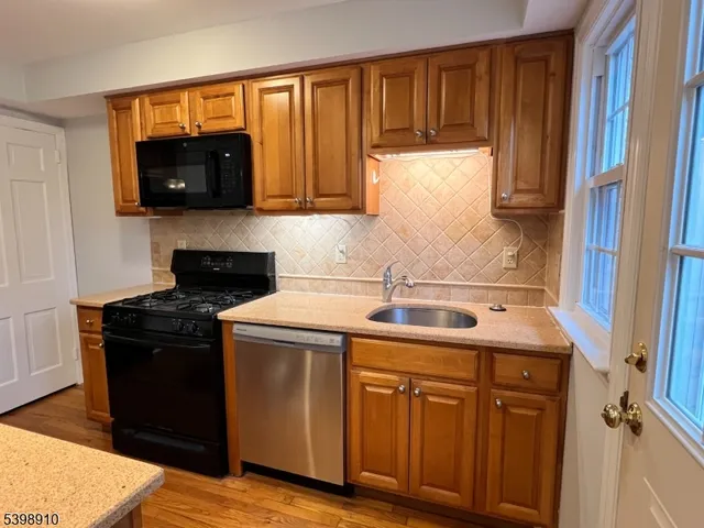 a kitchen with stainless steel appliances granite countertop a sink stove and microwave