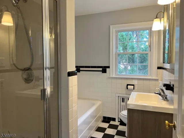 a bathroom with a sink a window and a shower