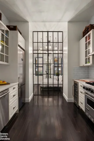 a view of a kitchen with stainless steel appliances wooden floor and a window