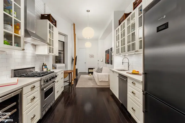a kitchen with stainless steel appliances a stove oven and white cabinets