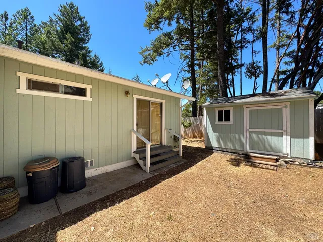 a backyard of a house with barbeque oven table and chairs