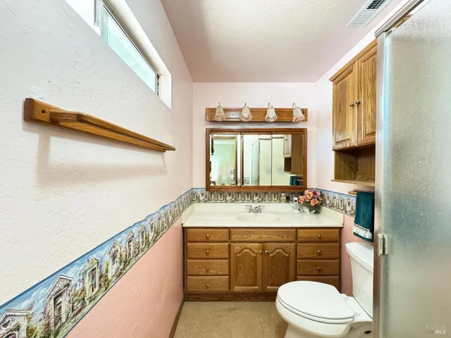 a bathroom with a sink a toilet and mirror