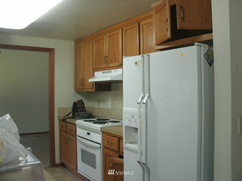 5528 133rd Avenue Southwest Rochester, WA 98579 - Photo 3 of 7 a kitchen with stainless steel appliances a refrigerator and a stove top oven