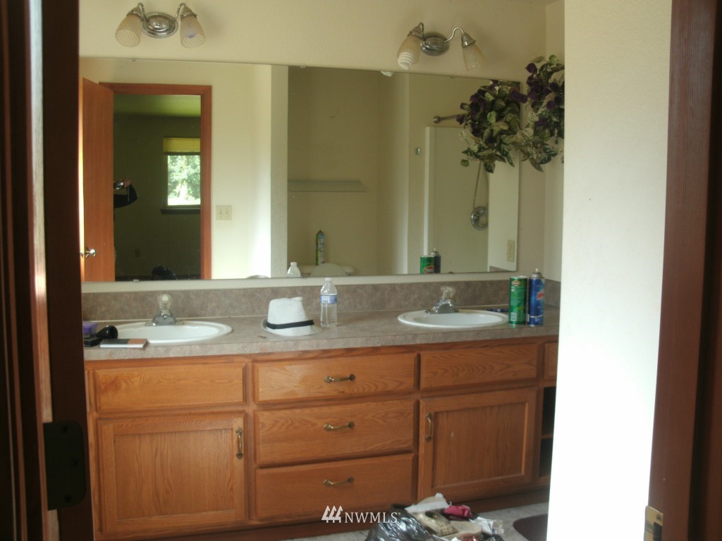 5528 133rd Avenue Southwest Rochester, WA 98579 - Photo 5 of 7 a bathroom with a granite countertop sink a mirror and a
