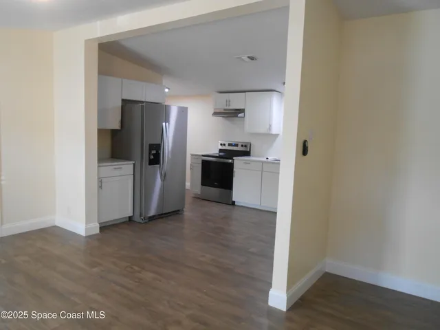 a view of a kitchen with a sink and a refrigerator