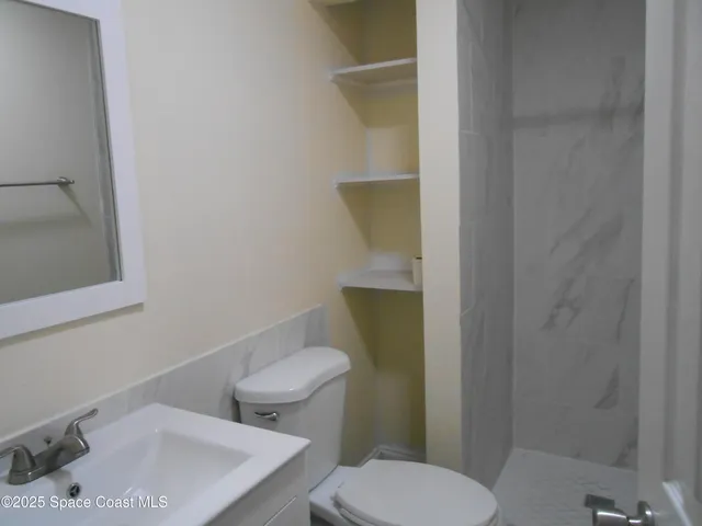 a white toilet sitting next to a bathroom sink