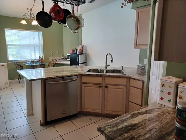 a kitchen with stainless steel appliances granite countertop a sink a stove and a wooden floors