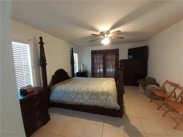 a spacious bedroom with a bed a lamp and a dresser