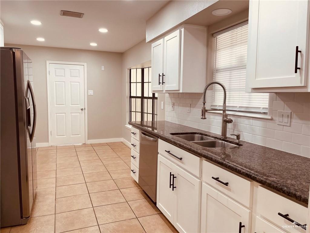 1206 Bluebird Avenue McAllen, TX 78504 - Photo 5 of 20 a kitchen with stainless steel appliances granite countertop a sink and a refrigerator