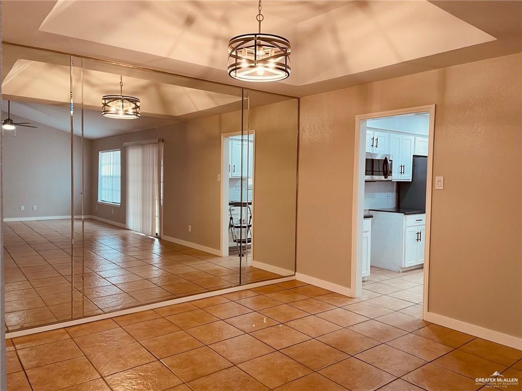 1206 Bluebird Avenue McAllen, TX 78504 - Photo 8 of 20 a view of a hallway with wooden floor and a kitchen