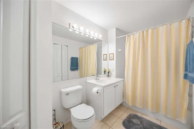 a view of a room that has a bed and a bookshelf in it