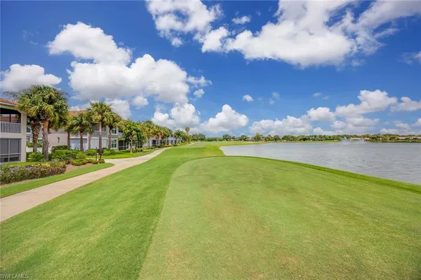 a view of a house with a big yard and a large tree