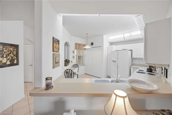 a kitchen with white cabinets and white appliances