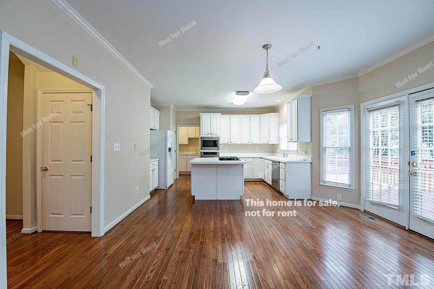 2340 Bolingbrook Lane Raleigh, NC 27613 - Photo 8 of 24 a living room with stainless steel appliances kitchen island hard wood floors and fireplace