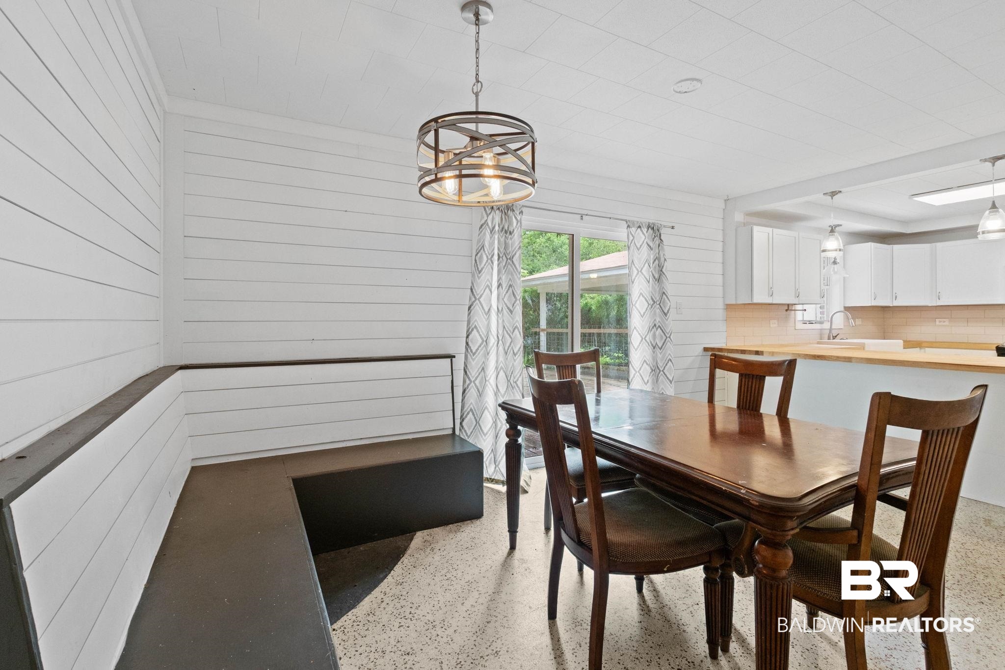 384 Old Bratt Road Atmore, AL 36502 - Photo 27 of 64 Dining area featuring shiplap walls, built-in bench seating, and a contemporary chandelier
