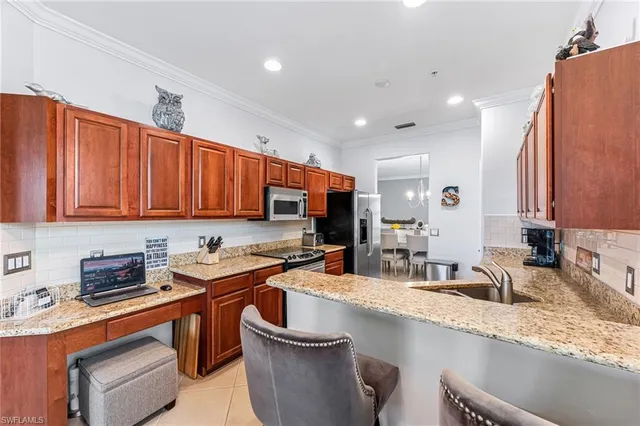 a kitchen with stainless steel appliances granite countertop a sink a stove and a refrigerator