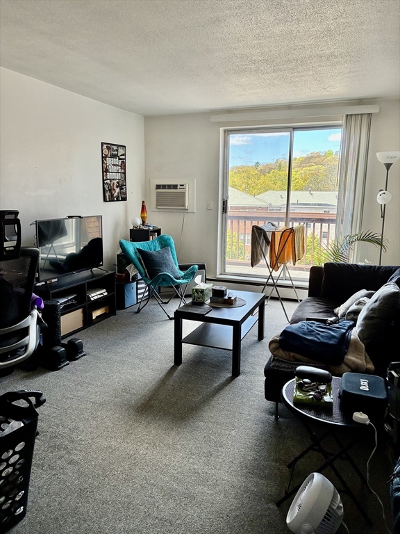 142 Kenrick Street, Unit 34 Boston, MA 02135 - Photo 1 of 8 a living room with furniture and a floor to ceiling window