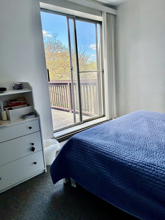 142 Kenrick Street, Unit 34 Boston, MA 02135 - Photo 2 of 8 a bedroom with a bed and a window