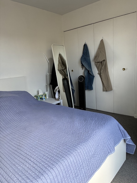 142 Kenrick Street, Unit 34 Boston, MA 02135 - Photo 4 of 8 a bed room with a bed