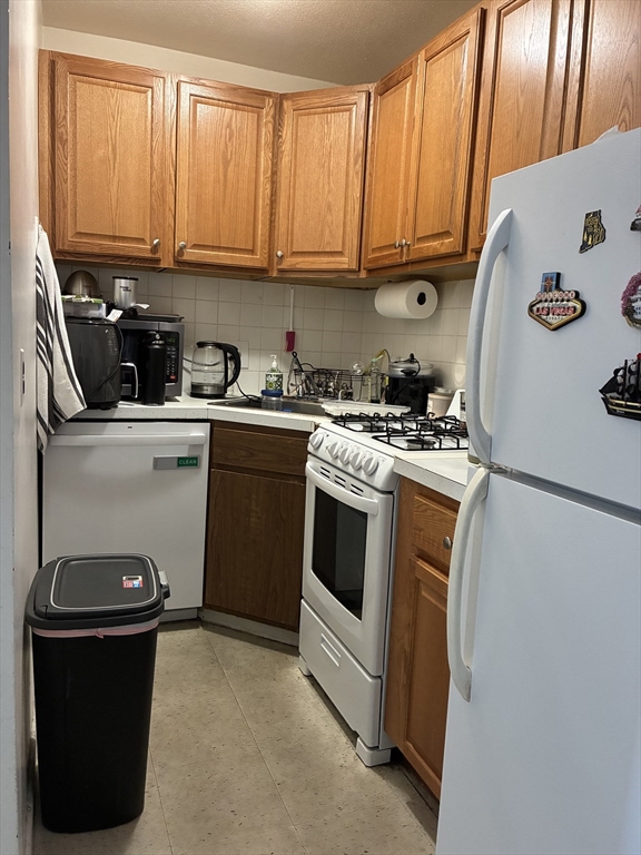 142 Kenrick Street, Unit 34 Boston, MA 02135 - Photo 5 of 8 a kitchen with a sink a stove and cabinets