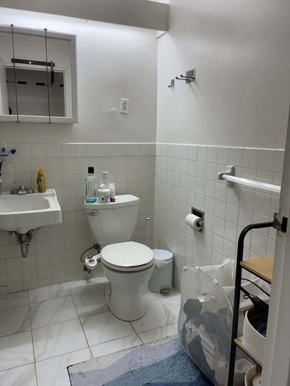 142 Kenrick Street, Unit 34 Boston, MA 02135 - Photo 7 of 8 a bathroom with a toilet sink and mirror