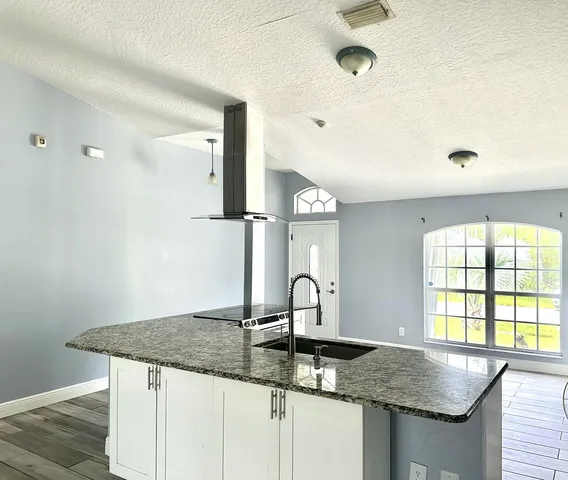 a kitchen with granite countertop a sink and a window