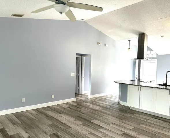 a view of a kitchen with a sink and wooden floor