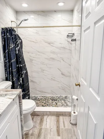 a bathroom with a sink a toilet and shower