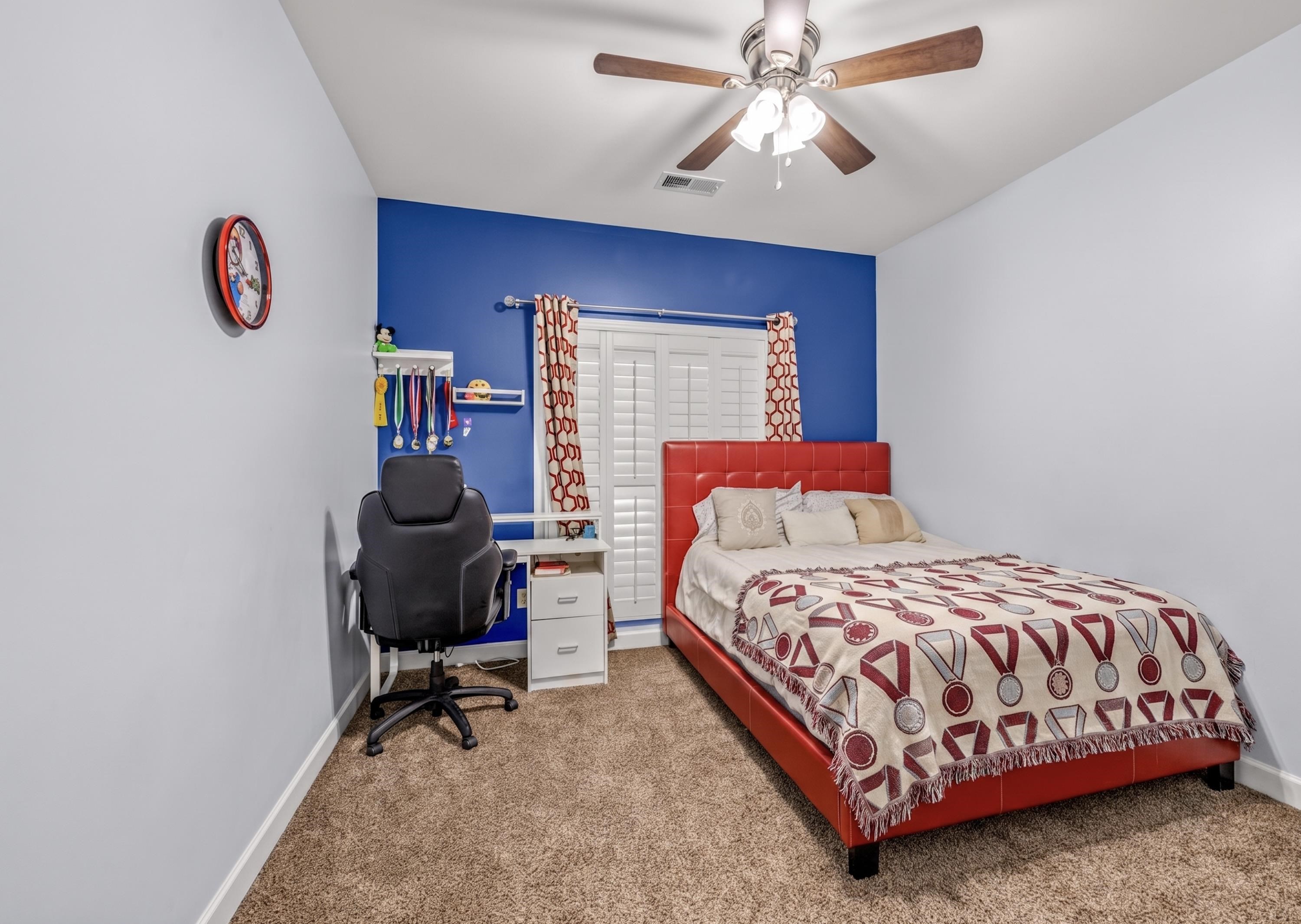 744 Southern Home Road Collierville, TN 38017 - Photo 22 of 24 Carpeted interior room featuring a contrasting accent wall, ceiling fan with light fixture, and white louvered window shutters