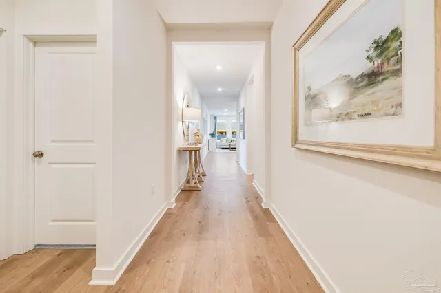 a view of a hallway with wooden floor and a living room