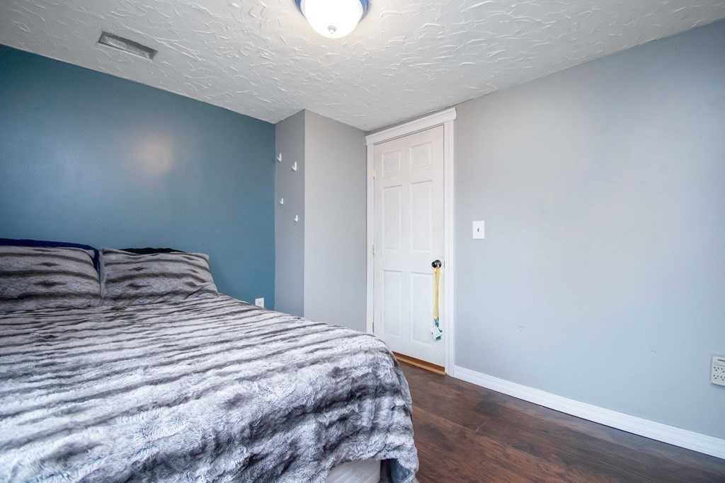 220 Nottingham Street Springfield, MA 01104 - Photo 24 of 30 a bedroom with a bed and wooden floor
