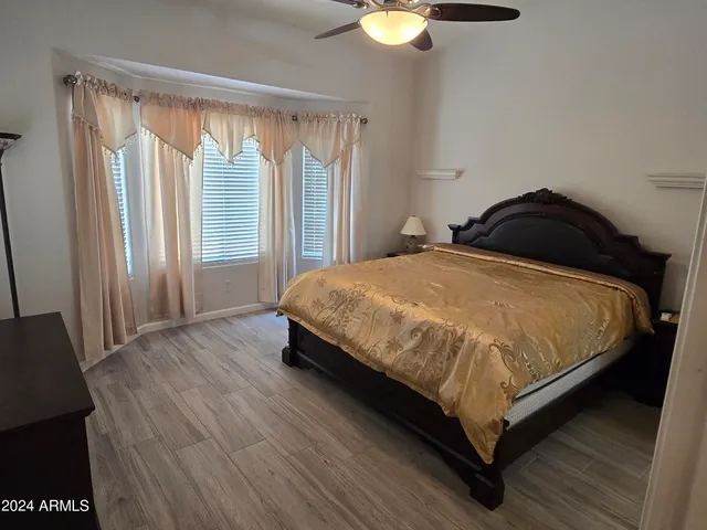 a bedroom with a bed lamp and a large window
