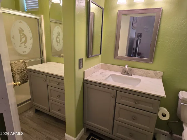 a bathroom with a sink mirror vanity and toilet
