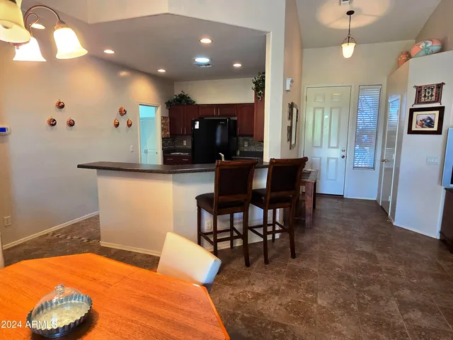 a living room with furniture a dining table and chairs with kitchen view